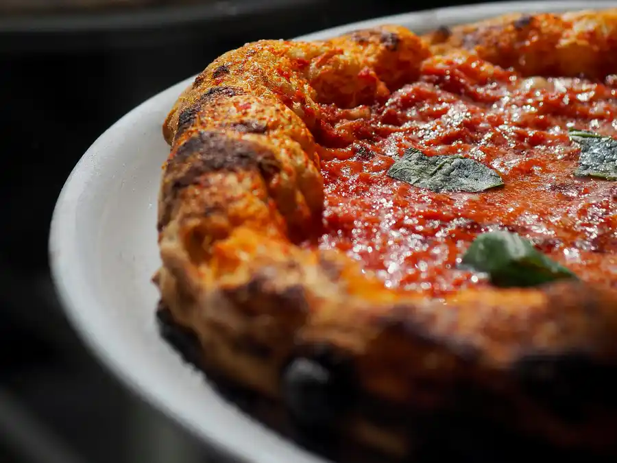Una margherita napoletana nel piatto, con il cornicione alto e bruciacchiato